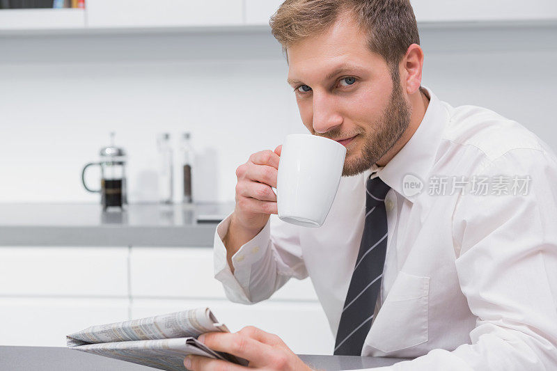 快乐的商人一边喝咖啡一边看报纸