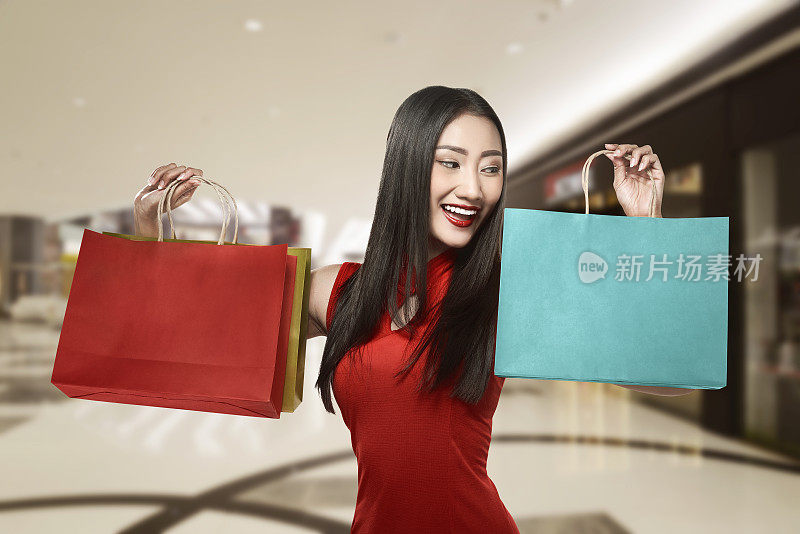 穿着旗袍拿着购物袋的中国妇女