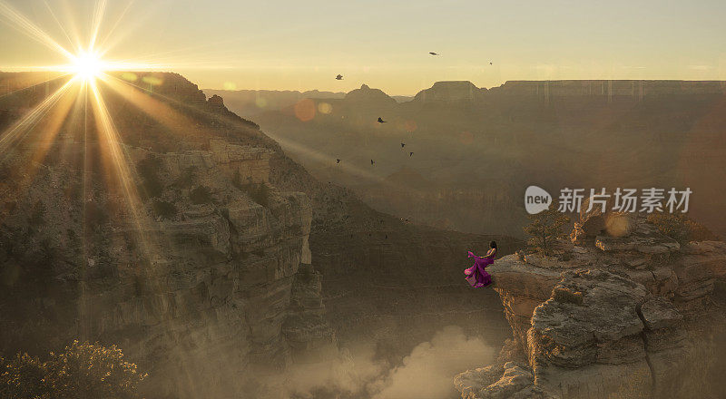 身着紫色裙子的女人坐在大峡谷的边缘