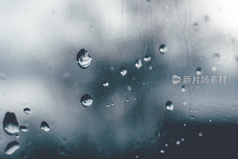 当它在秋天下雨的时候，在窗玻璃上柔和的水滴的特写