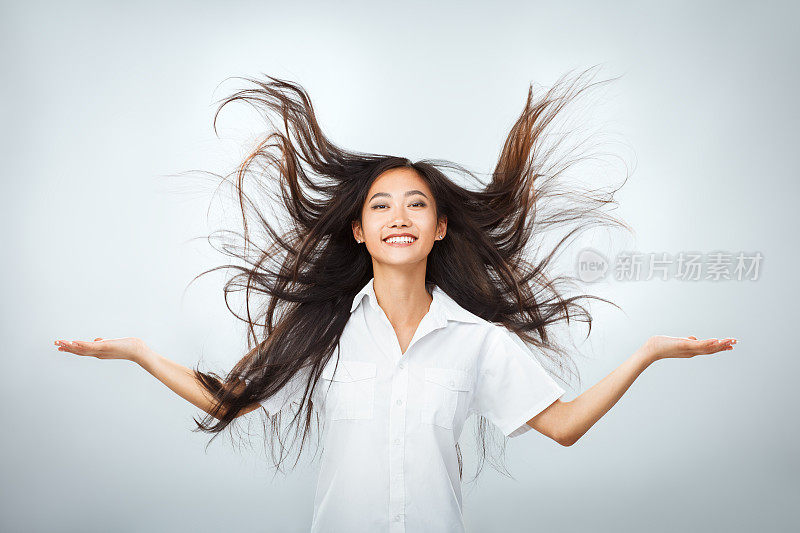 快乐年轻的亚洲女人美丽的飞长头发