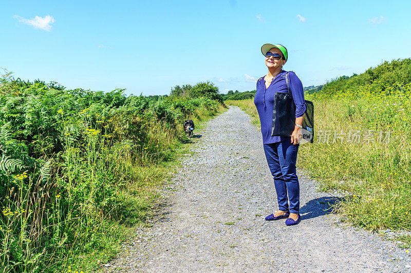 在乡村小路上的成熟微笑的西班牙妇女