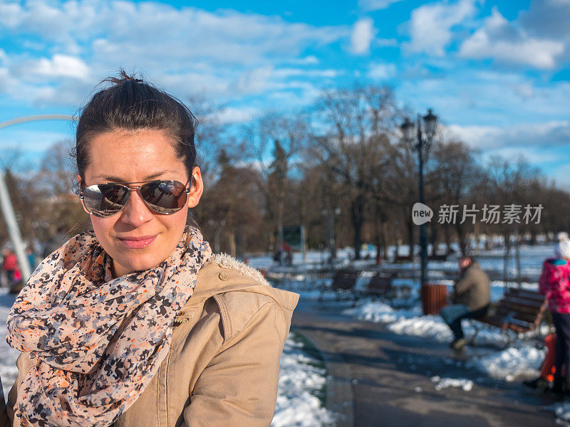 在阳光明媚的冬日，戴着太阳镜的女孩享受着好天气