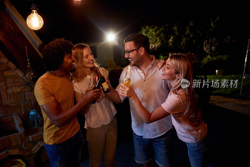 愉快的朋友们晚上在露台上举行饮酒聚会。