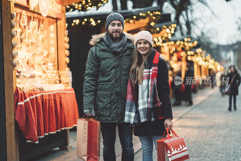 快乐的年轻夫妇在圣诞市场