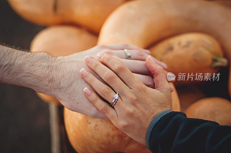 新婚夫妇在秋天举起结婚戒指
