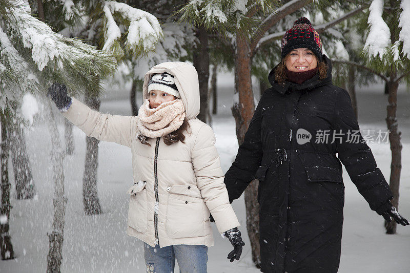 妈妈和女儿在雪中玩耍