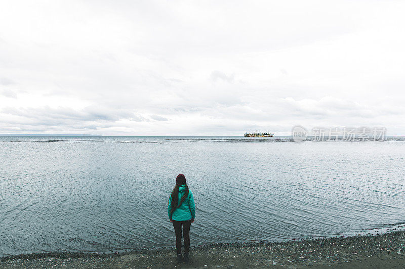 一个女人在海滩上散步，看着蓬塔阿里纳斯的沉船