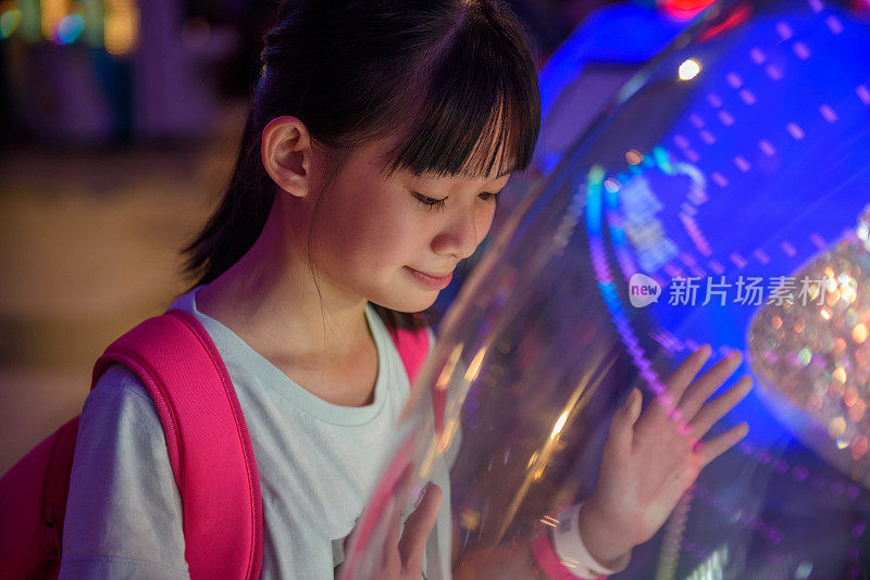 年轻的亚洲女孩玩电玩机
