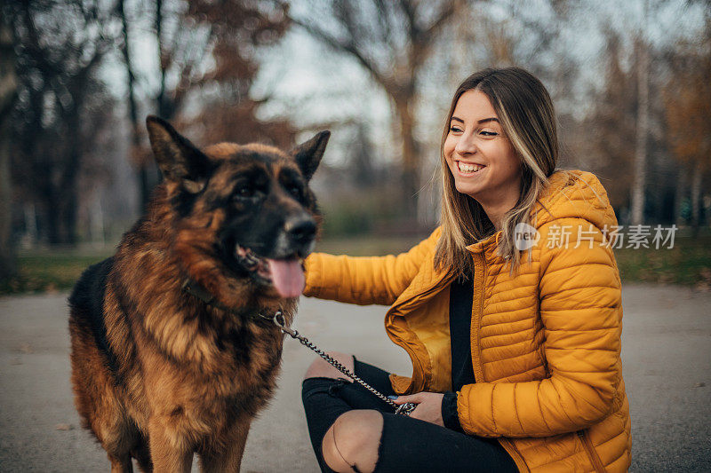 年轻女子和德国牧羊犬在公园里玩