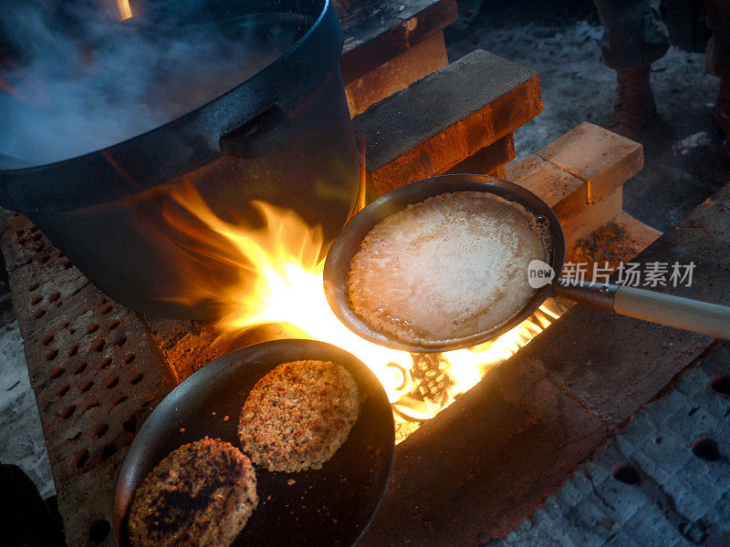 烹饪素食馅饼，煎饼和Lohikeitto汤在炉火上