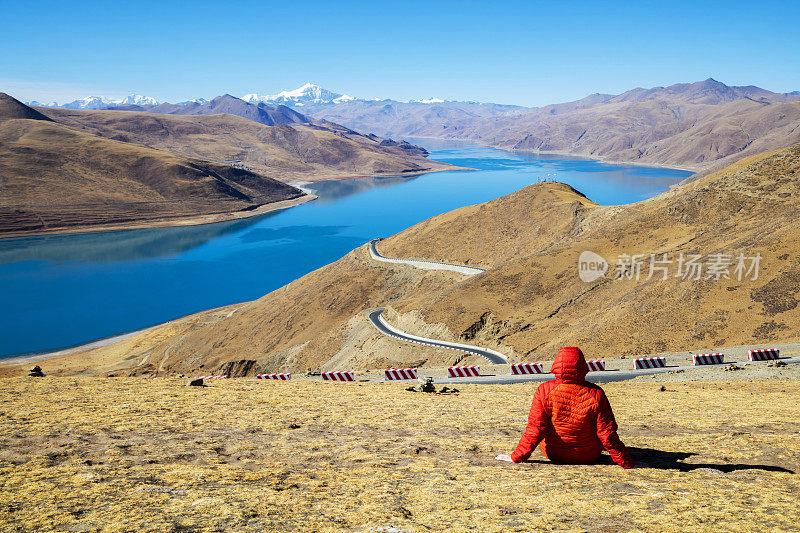 女徒步者坐在山上看在西藏的羊卓雍错湖，风景风景的喜马拉雅