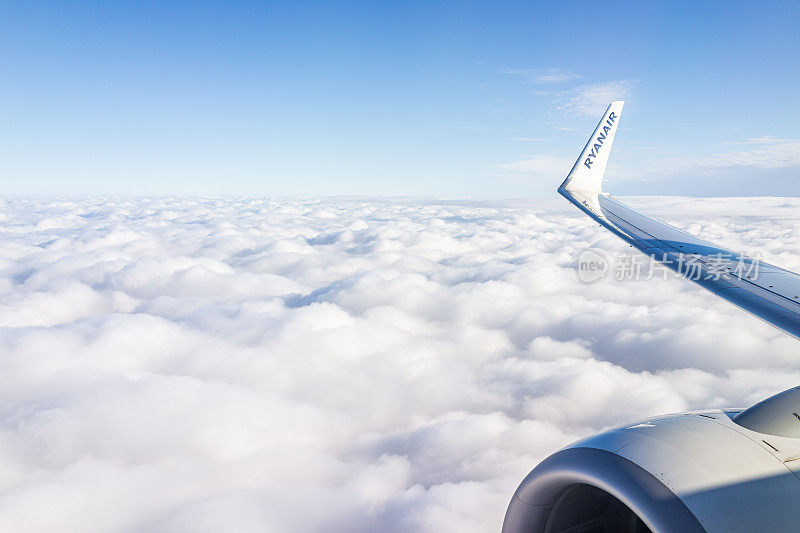 白云和清澈的蓝天地平线从窗口鸟瞰瑞安航空飞机