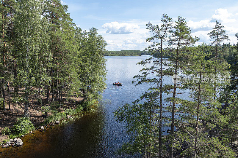 自然景观。森林和湖，人在船。芬兰国家公园。