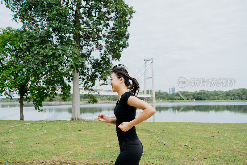 精力充沛的亚洲华人女子早上在公园跑步