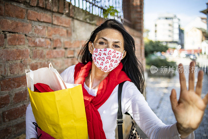 一名皮肤有白癜风的老年妇女戴着防护口罩——她买了一副防护口罩回来，因为冠状病毒大流行