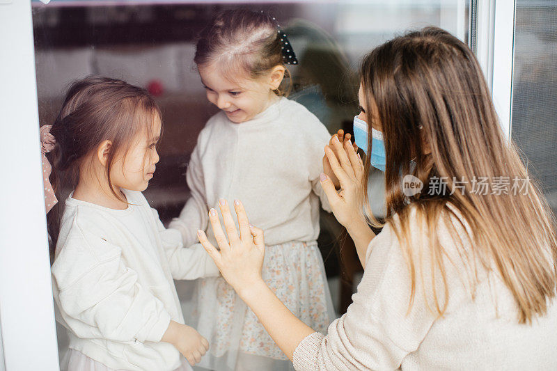 一个女儿通过窗户探望被隔离的母亲，防止她感染冠状病毒