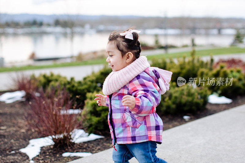 可爱的蹒跚学步的女孩在公园里跑步和玩耍