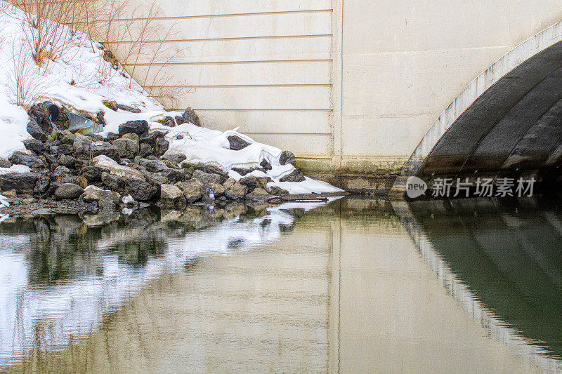 桥隧道与雪覆盖的河岸相遇