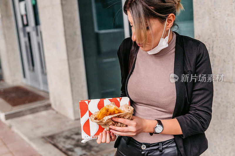 年轻女子边走边吃糕点