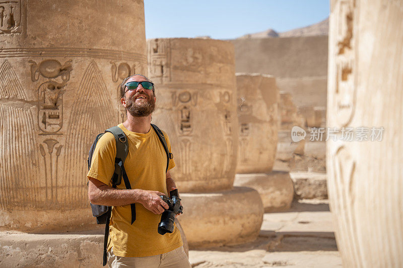 一名男性游客在埃及古庙内拍照