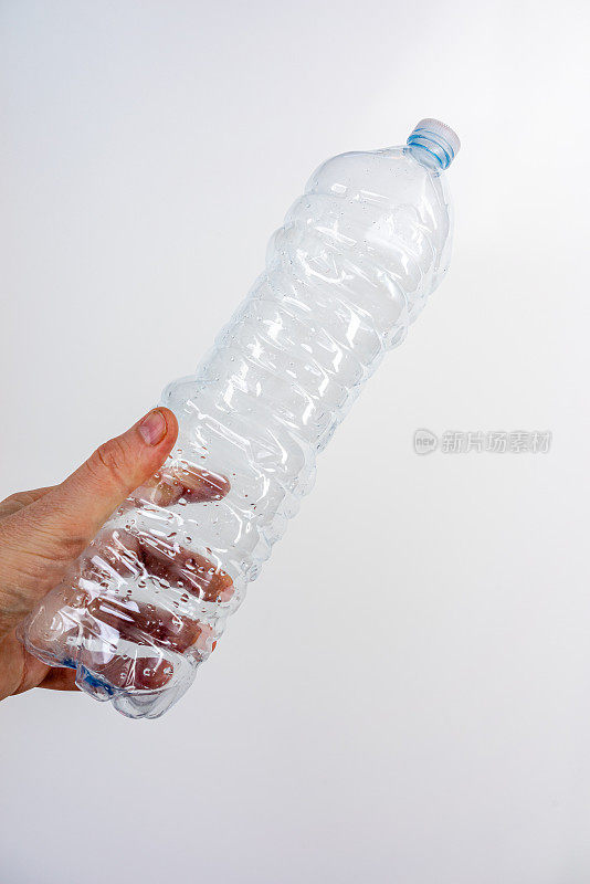 手里拿着一个塑料水瓶