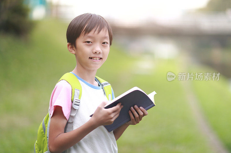 小男孩背着书包走回学校