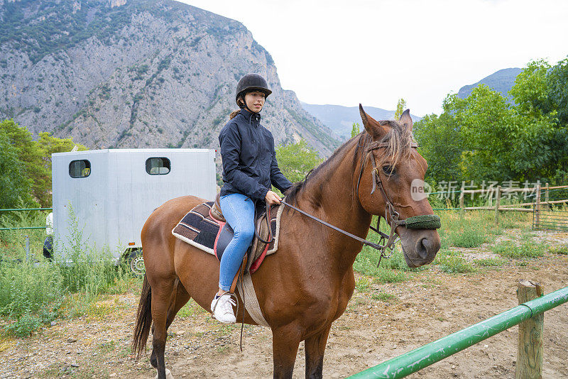 十几岁的女孩在比利牛斯山谷骑着棕色的马