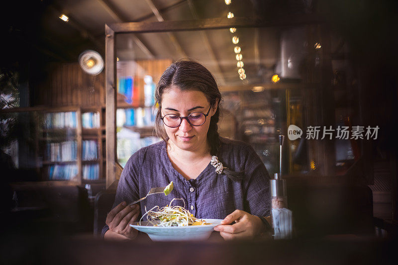 在餐厅吃沙拉的女人