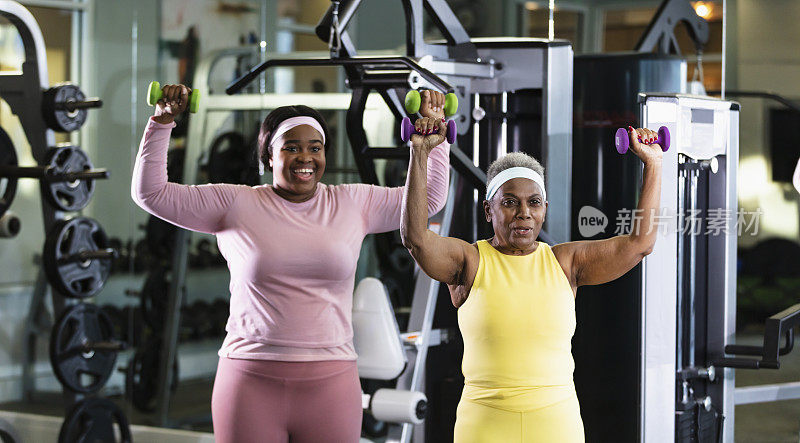 非裔美国女性在健身房用哑铃锻炼