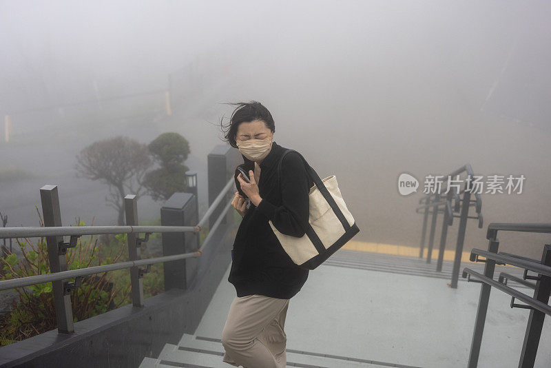 在雾蒙蒙多风的山上观察点参观的妇女