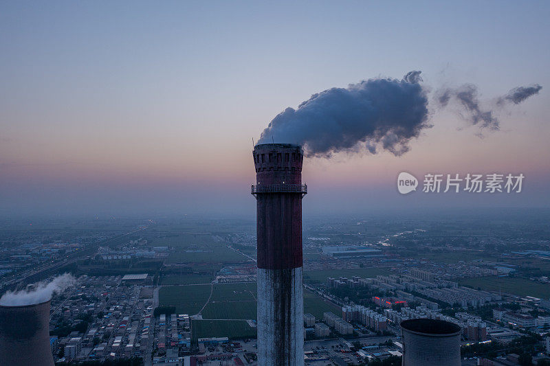 鸟瞰图，燃煤电厂的高管与黑烟上升污染大气在日出