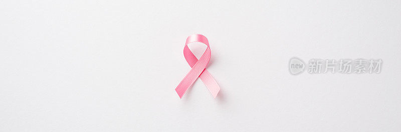 俯视图照片的粉红色绸带象征乳腺癌意识在孤立的白色背景