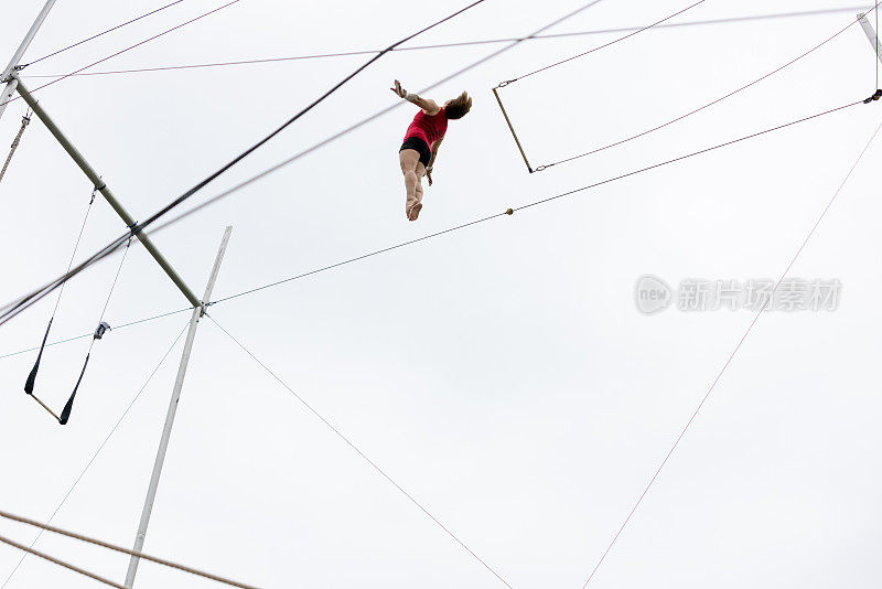 成熟的女性空中飞人艺术家在天空中飞翔