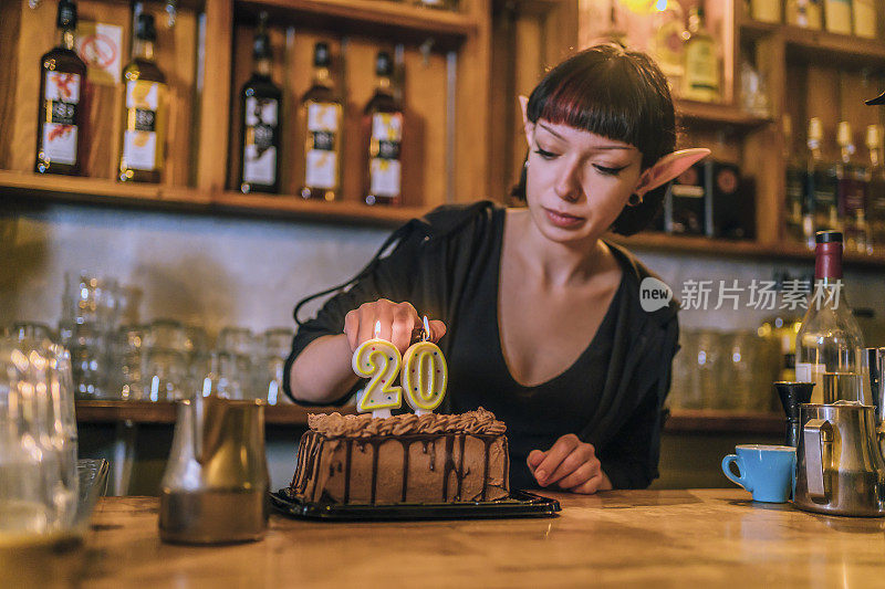 女咖啡师在生日蛋糕上点蜡烛