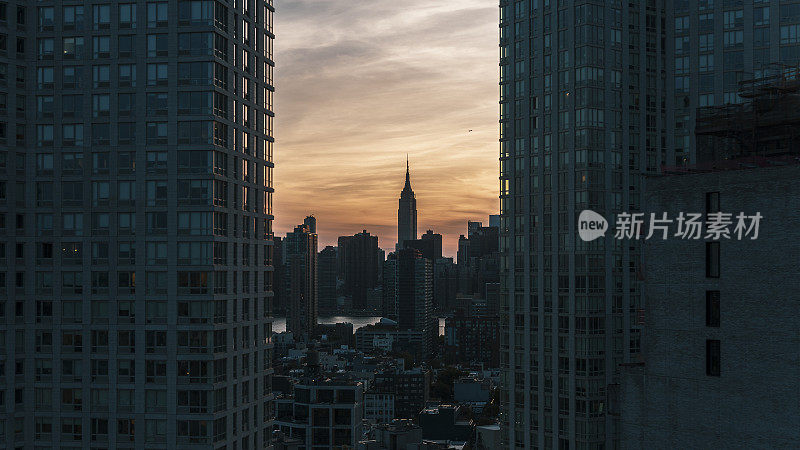 帝国大厦的剪影在曼哈顿的两个现代化的塔在长岛市，皇后区夜间。