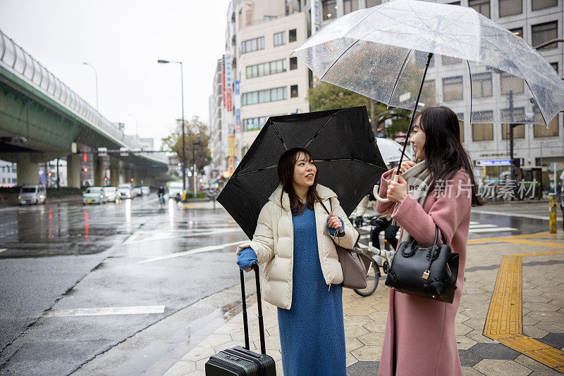 女性朋友在雨天在街上聊天