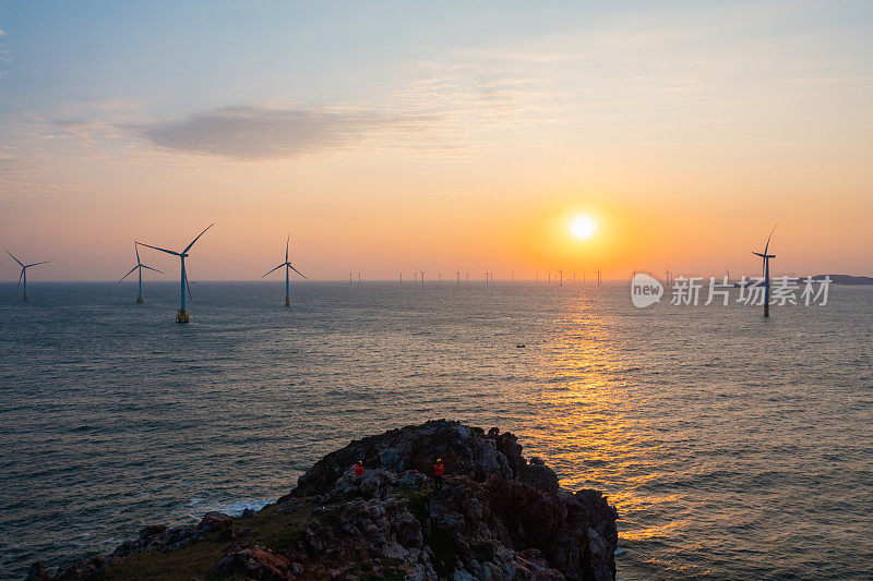 海上风力发电厂和电气工程师在日出