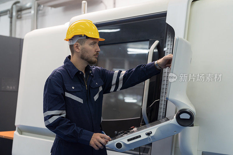 男性工程师，在工业工厂的生产线上操作数控铣床。男性工程师工人在工厂控制数控机床的车削和铣削