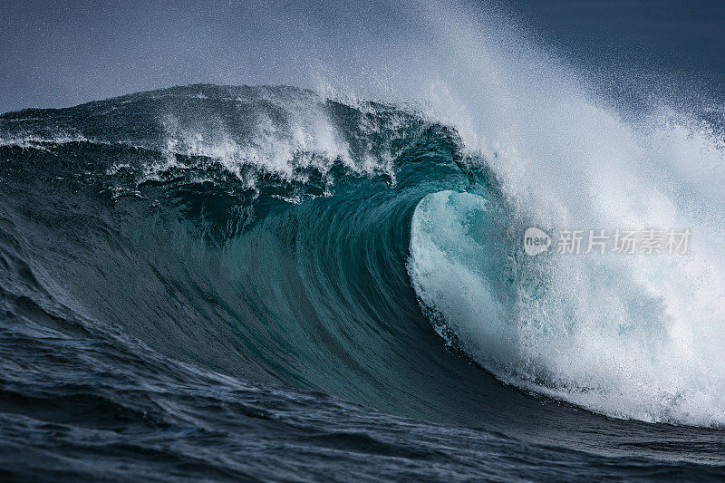 强大的蓝色海浪冲击着浅滩礁石