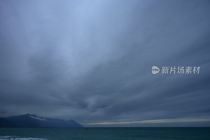 蓝蓝的天空中，云引人注目。多层云从远处看是由黑云和白云组成的。