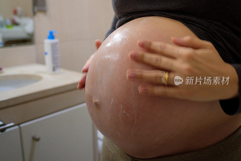 孕妇用乳霜和油擦腹部来去除妊娠纹