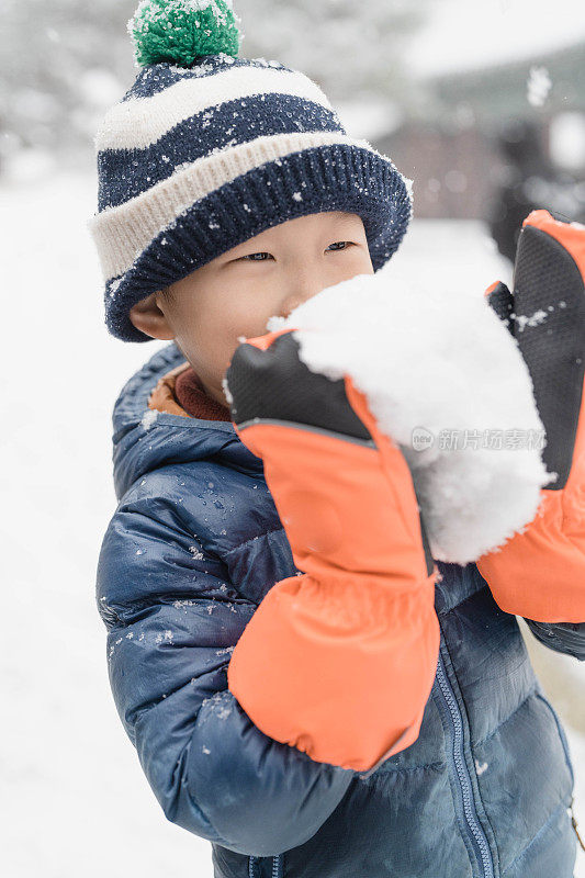 现代都市下雪天男孩的嬉闹