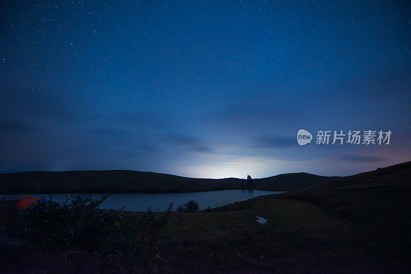 山顶上的夜晚，星空和湖水。