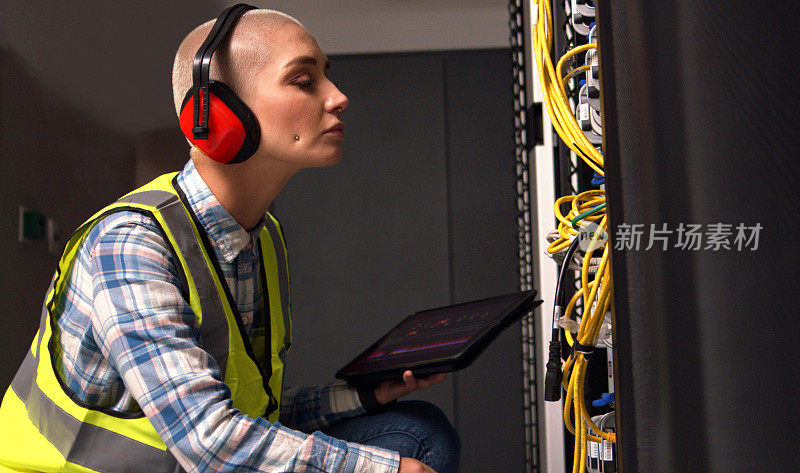 平板电脑，服务器机房维护和女工程师检查网络连接或布线。网络安全、数据库和信息技术与IT配套的专业测试存储硬件