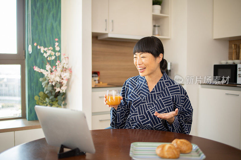 年轻女子在家里拿着一台数码平板电脑