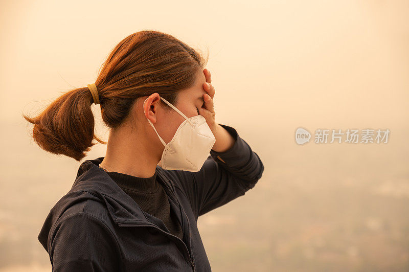 亚洲妇女因严重的空气污染(PM2.5)而头痛。