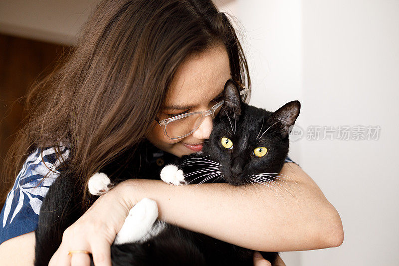 一个年轻女子的肖像，她的猫面对着她的脸