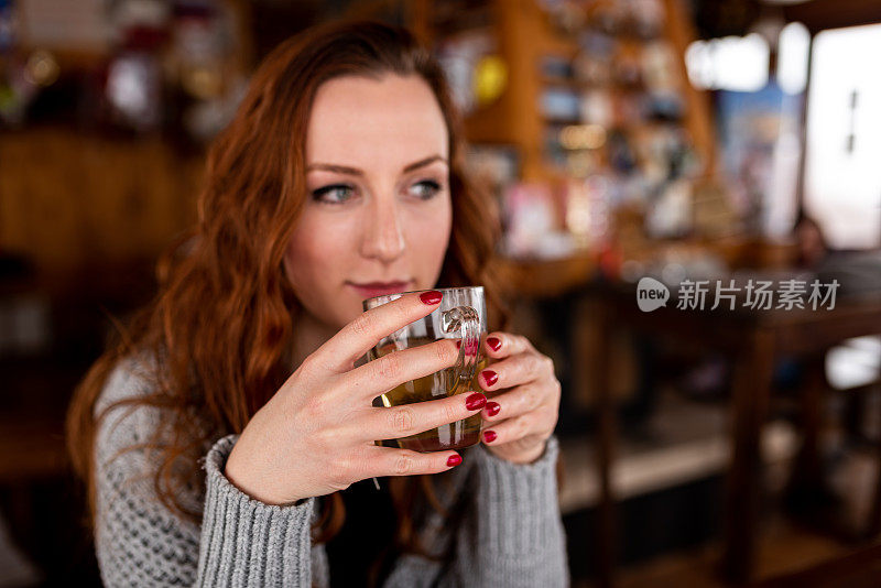 漂亮的年轻女人在咖啡馆喝茶存货照片