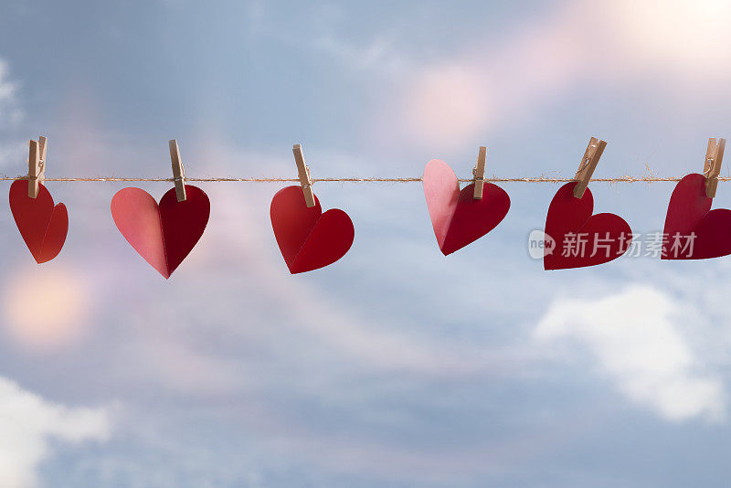 红纸做的心挂在绳子上，有插销。空气中弥漫着爱。情人节的概念。
